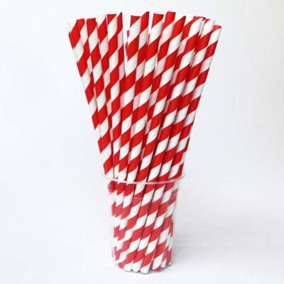 glass filled with red and white striped paper straws.