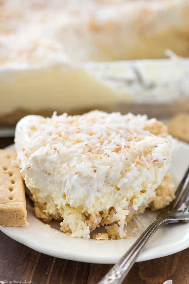 Slice of Coconut Shortbread on a small white plate with a silver fork.