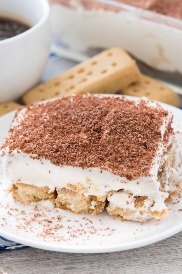 Shortbread-keksejä Tiramisu -jälkiruokaa pienellä valkoisella lautasella.