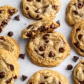 chocolate chip cookies on gray background with one cut in half