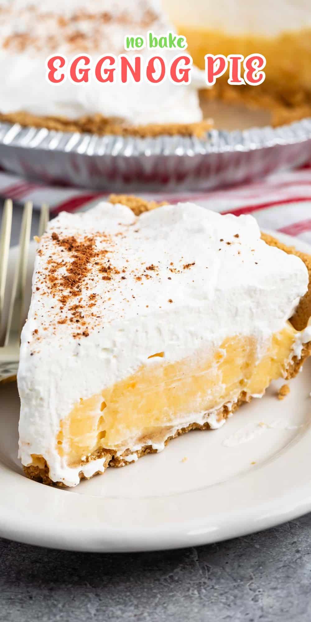 A close-up of a delectable slice of no-bake Eggnog Pie on a plate, crowned with whipped cream and a hint of spice. In the background, the remaining pie sits invitingly in its dish. Text on the image reads no bake Eggnog Pie.