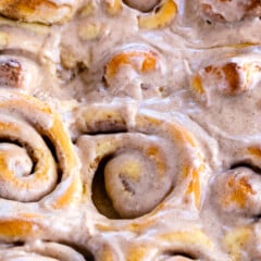 close up of pan of cinnamon rolls with icing