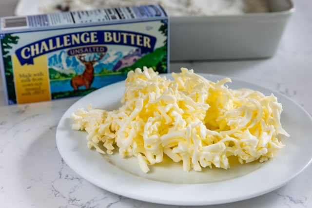 grated butter on white plate with challenge butter box behind