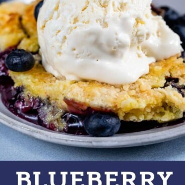 blueberry dump cake with ice cream on plate with color block text below
