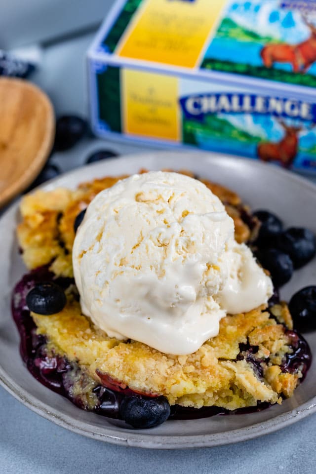 blueberry cobbler ala mode on gray plate with challenge butter box behind