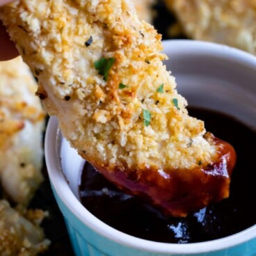 hand dipping chicken tender in bbq sauce with words on photo