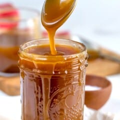 spoon above jar of caramel dripping caramel back into jar.