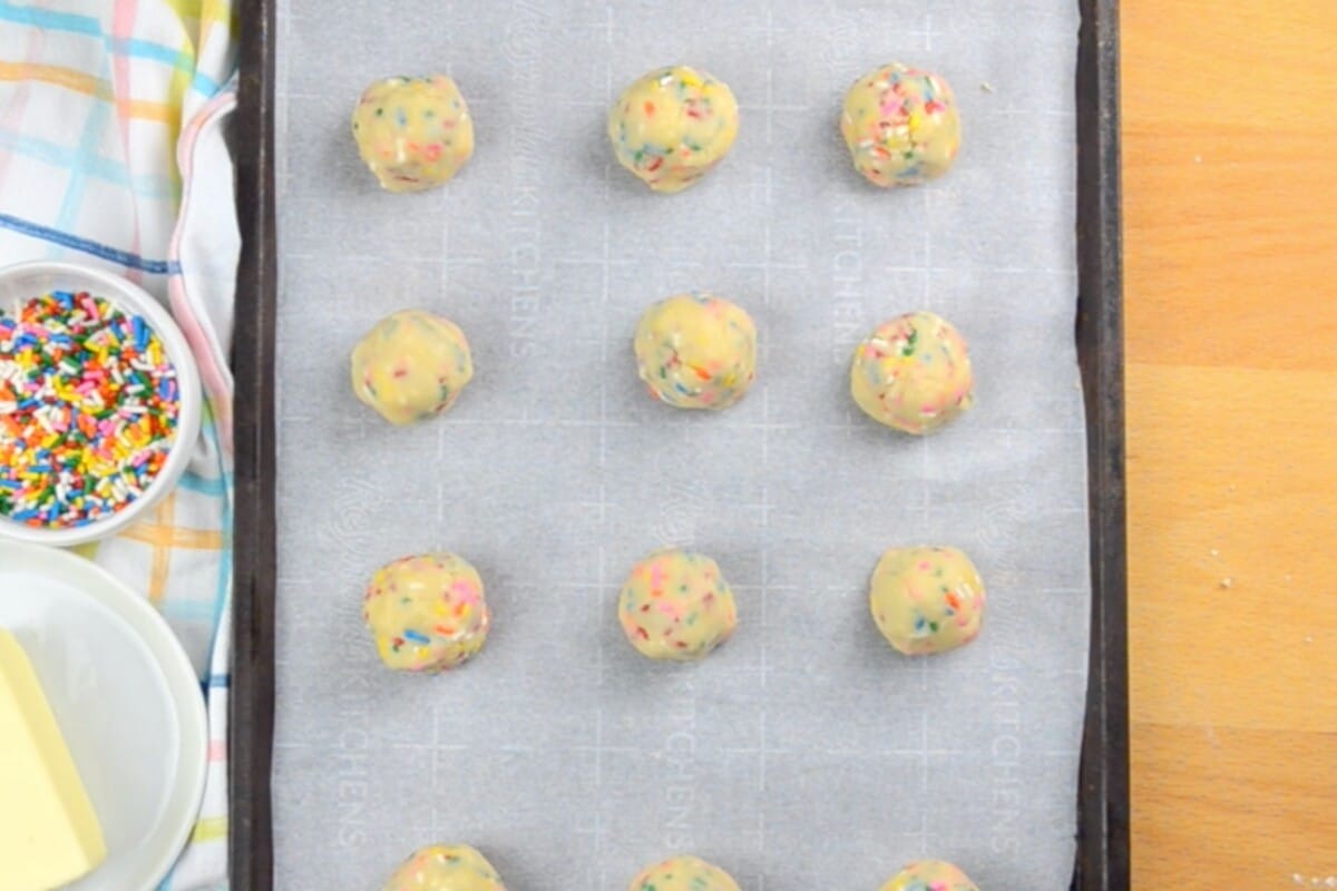 cookie dough balls on parchment lined cookie sheet.