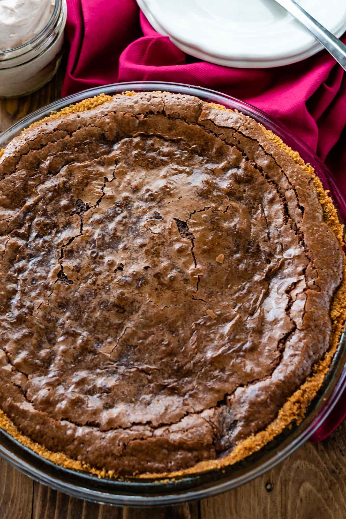 overhead of chocolate pie in graham cracker crust with pink napkin