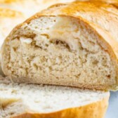 Two loaves of homemade french bread with one sliced