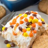 One slice of no bake peanut butter icebox cake on a plate next to a peanut butter cookie