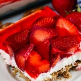 One large slice of strawberry pretzel salad on a white plate