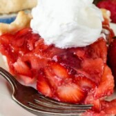 One slice of fresh strawberry pie topped with whipped cream