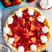 overhead shot of pie with whipped cream and berries around.