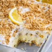 No bake lemon dessert in a glass baking dish with on corner piece missing