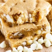 Stack of white chocolate blondies with top blondie missing a bite