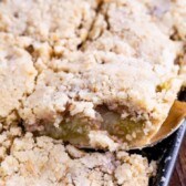 Overhead shot of apple slab pie with one piece being scooped out