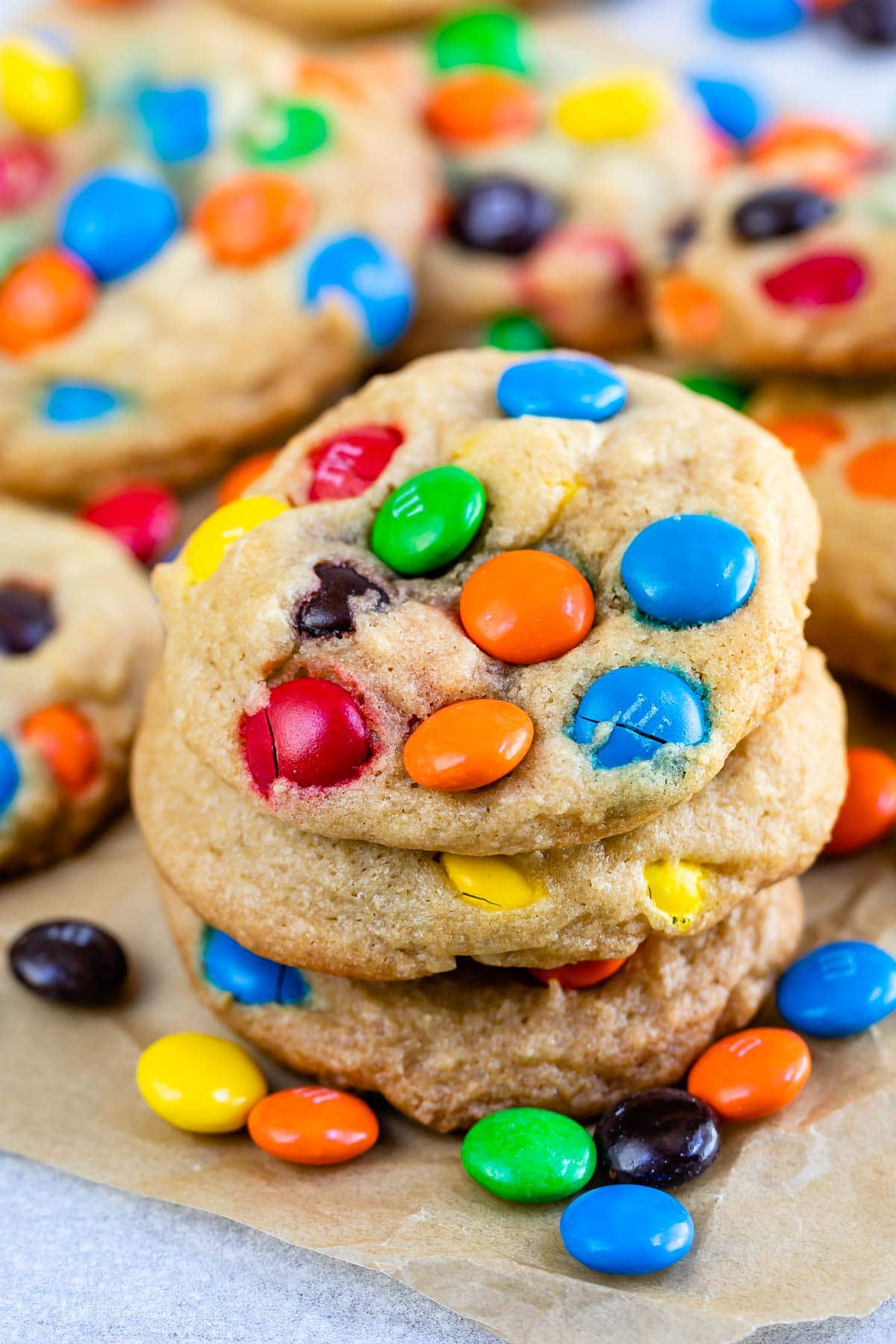 Stack of chocolate chip M&M cookies on parchment paper