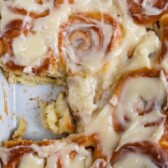 Overhead shot of perfect overnight cinnamon rolls in baking dish with one missing