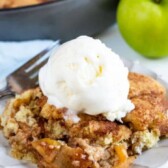 Slice of snickerdoodle apple cobbler with a scoop of vanilla ice cream on top