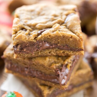 Three pumpkin nutella cookie bars with a pumpkin candy next to it