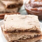 Two apple butter pie bars on a plate with a fork