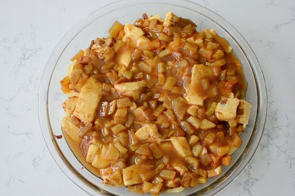 apples and chopped up cinnamon rolls in pie plate.