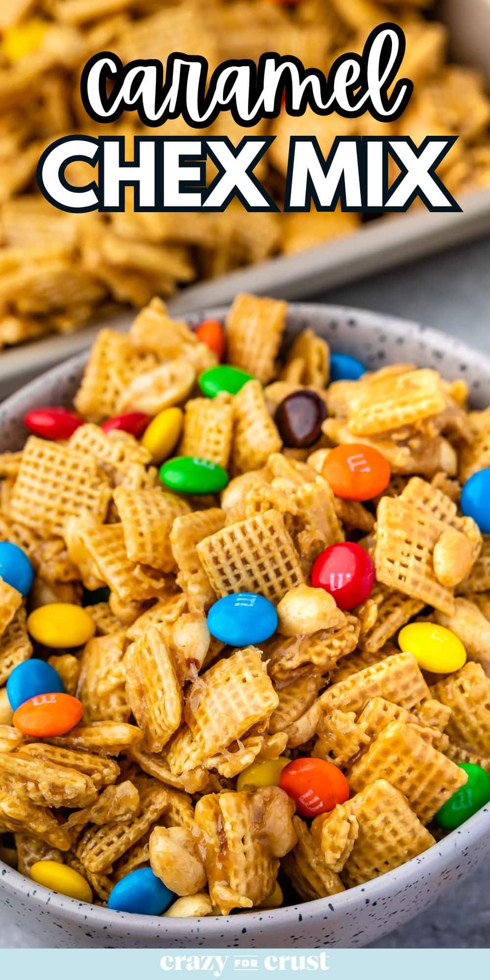 bowl of Chex mix with M&Ms with pan of mix behind and words on photo.