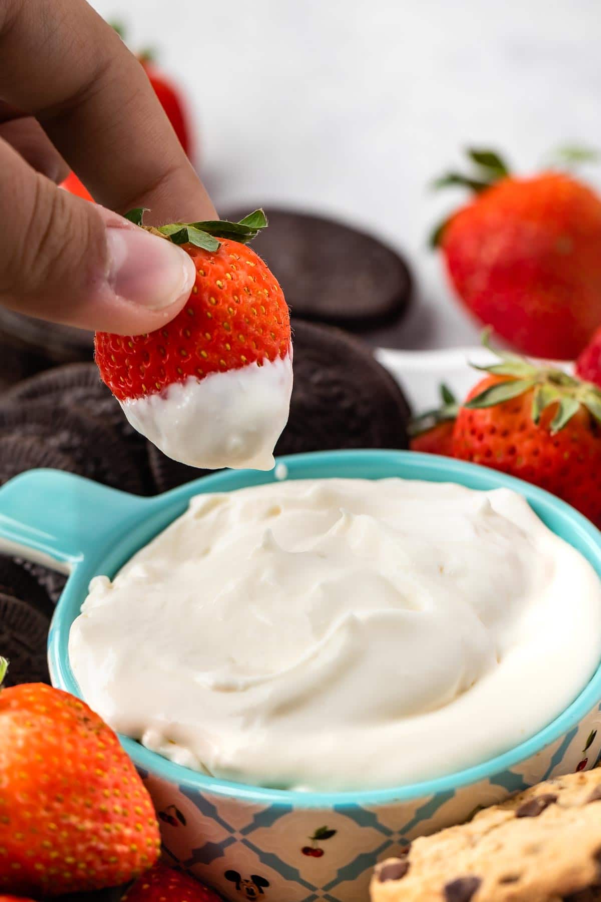 Strawberry above the cheesecake dip after being dipped in it