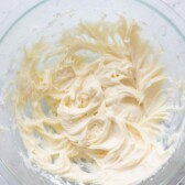 Overhead shot of cream cheese frosting in glass mixing bowl