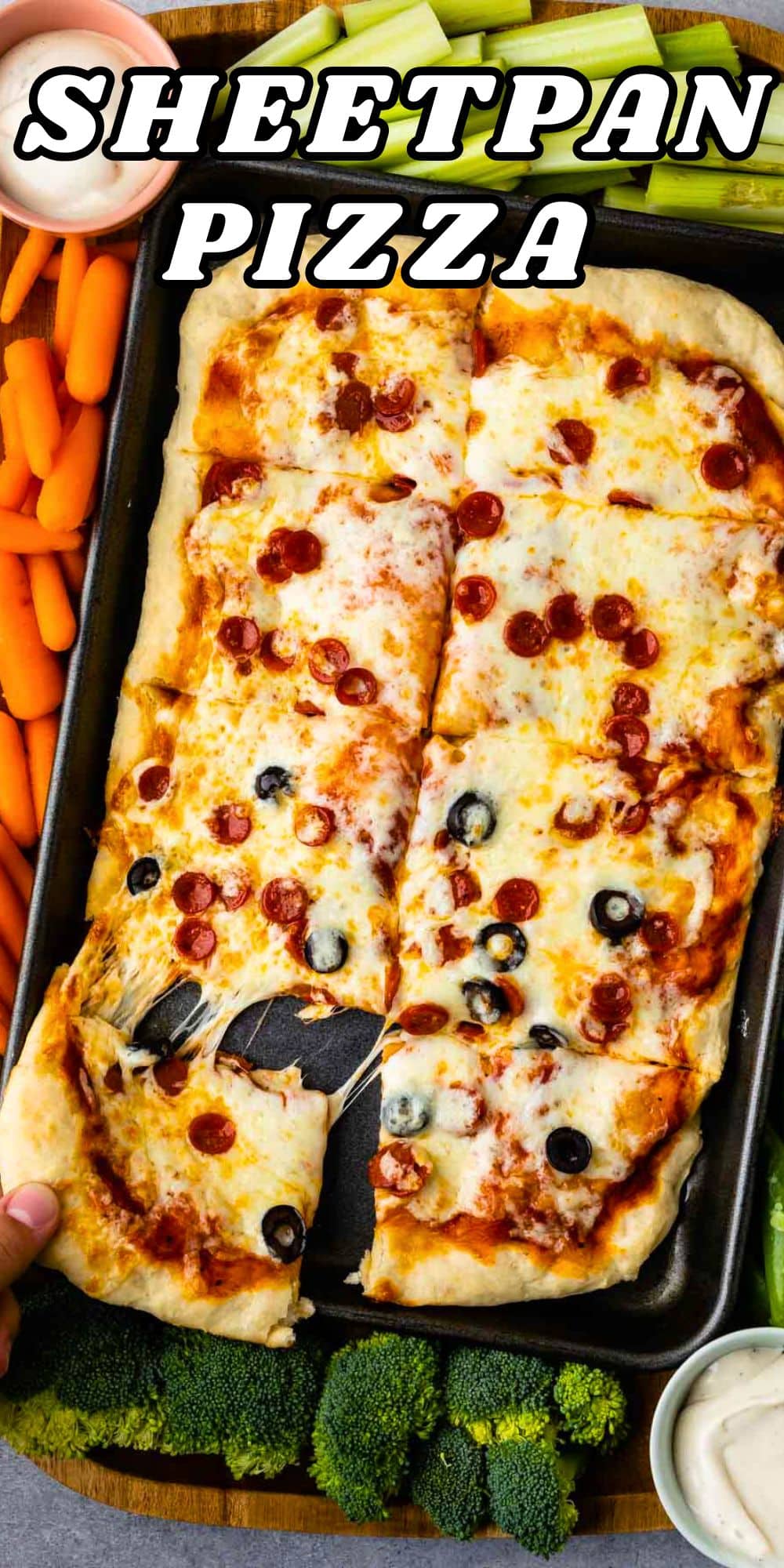 A delicious sheet pan pizza adorned with melted cheese, pepperoni, and olives is sliced and served. Fresh carrots, celery sticks, broccoli, and ranch dip elegantly surround the pan. As a hand reaches for a slice, Sheetpan Pizza text elegantly overlays the enticing image.