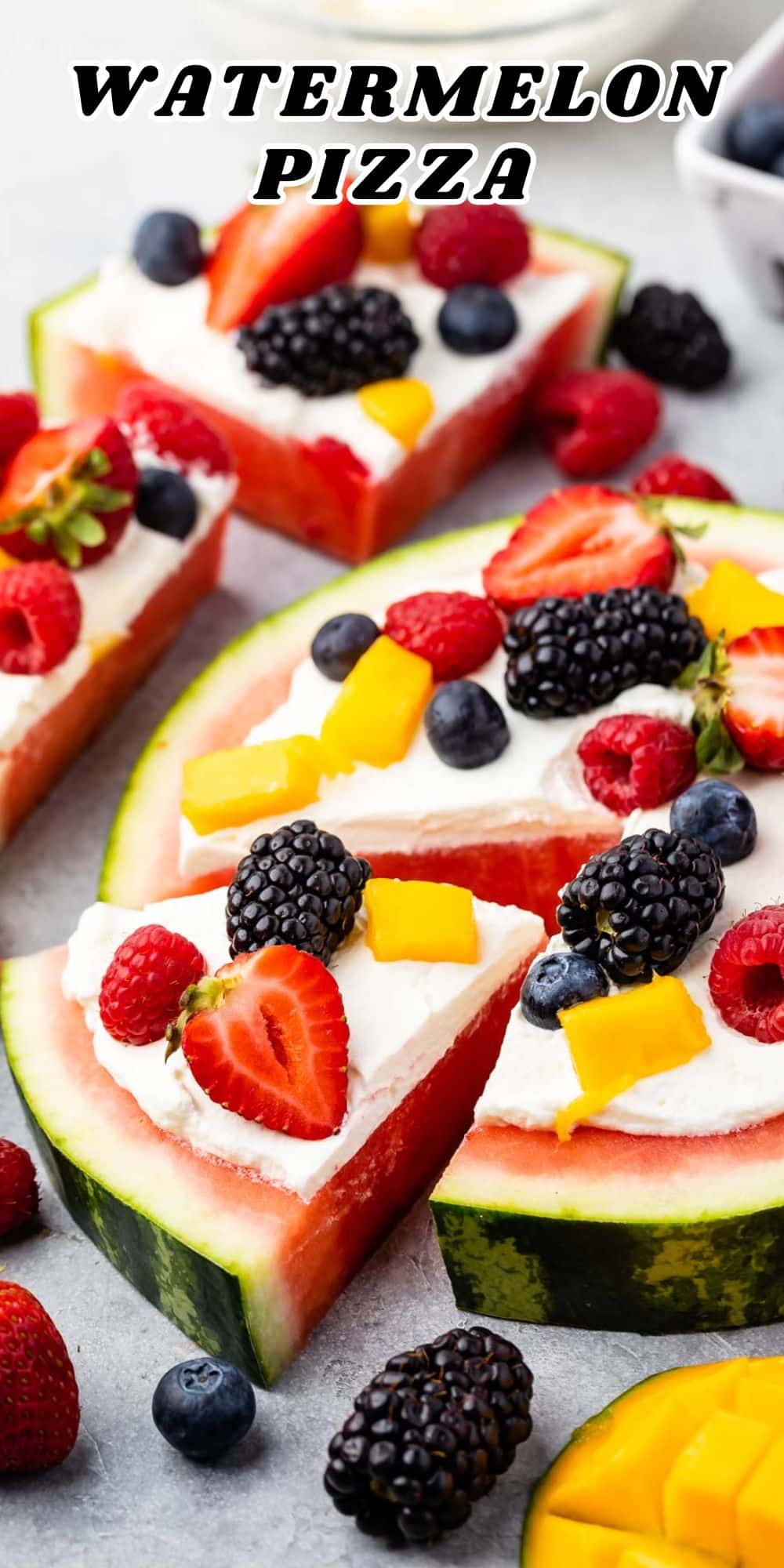 A colorful watermelon pizza features slices of juicy watermelon topped with whipped cream, strawberries, blackberries, blueberries, and mango, all artfully arranged to resemble pizza slices.