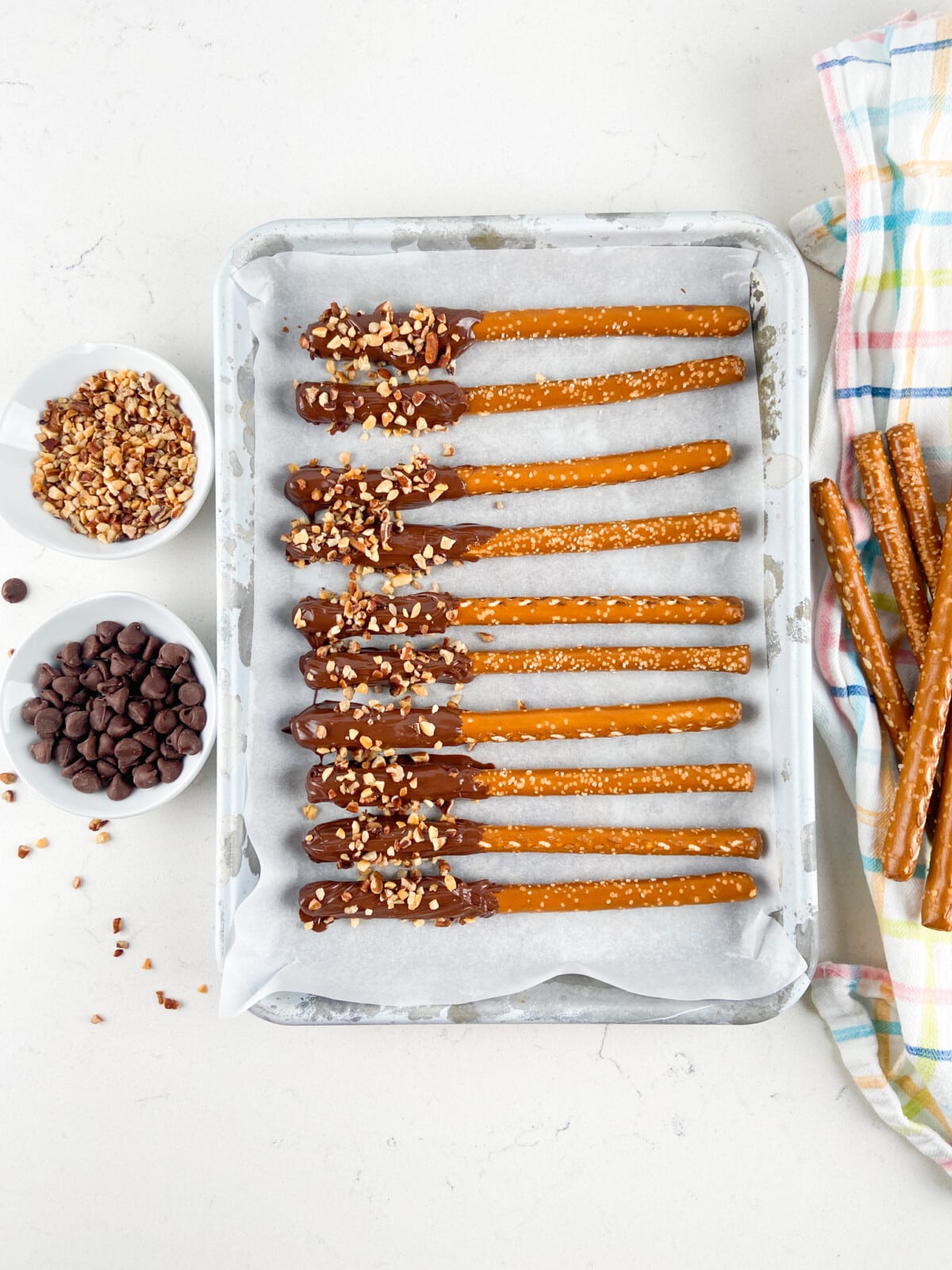 dipped pretzels on cookie sheet covered in parchment paper.