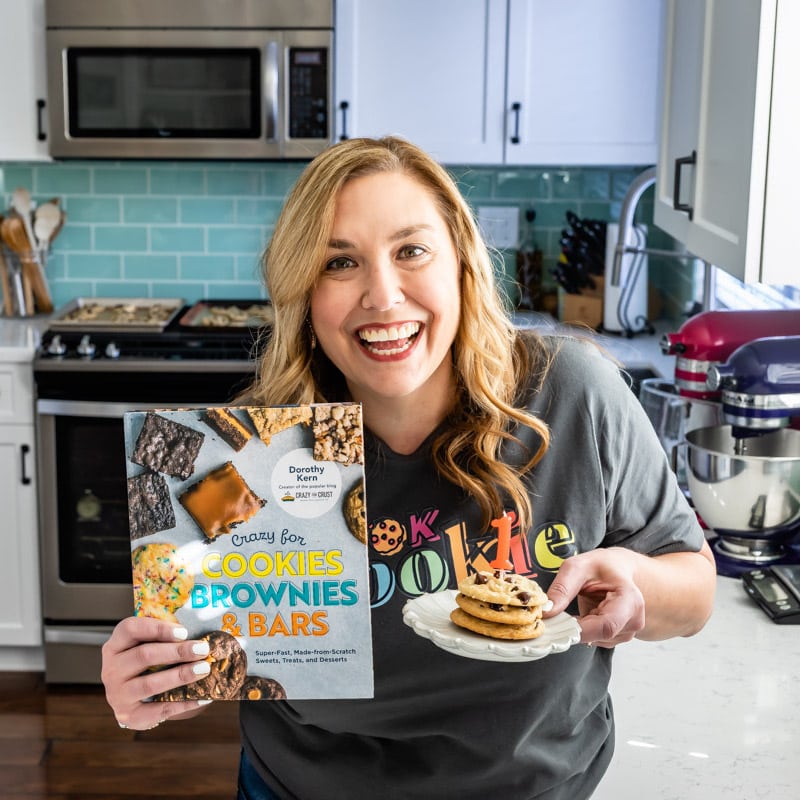 woman holding book and cookies on plate