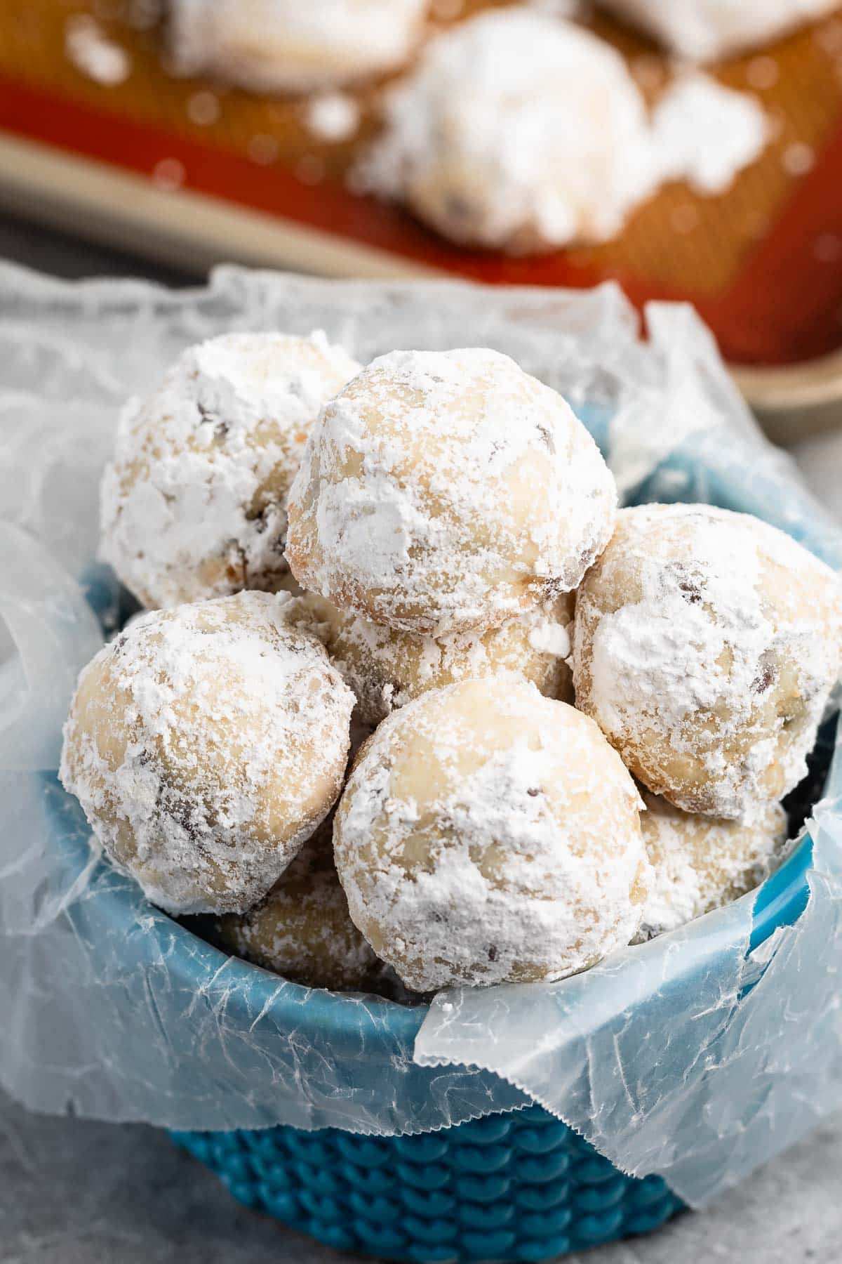 stacked snowballs covered in powdered sugar with chocolate chips baked in.