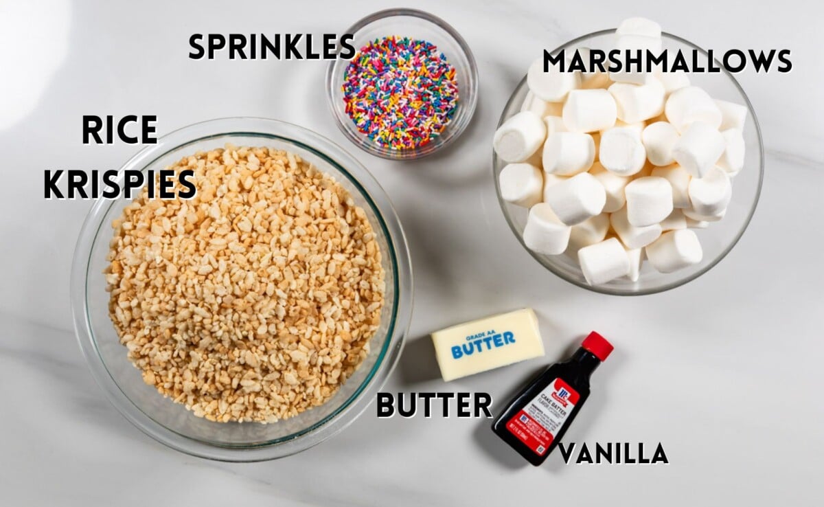 ingredients in cake batter Rice Krispie treats laid out on a marble counter.
