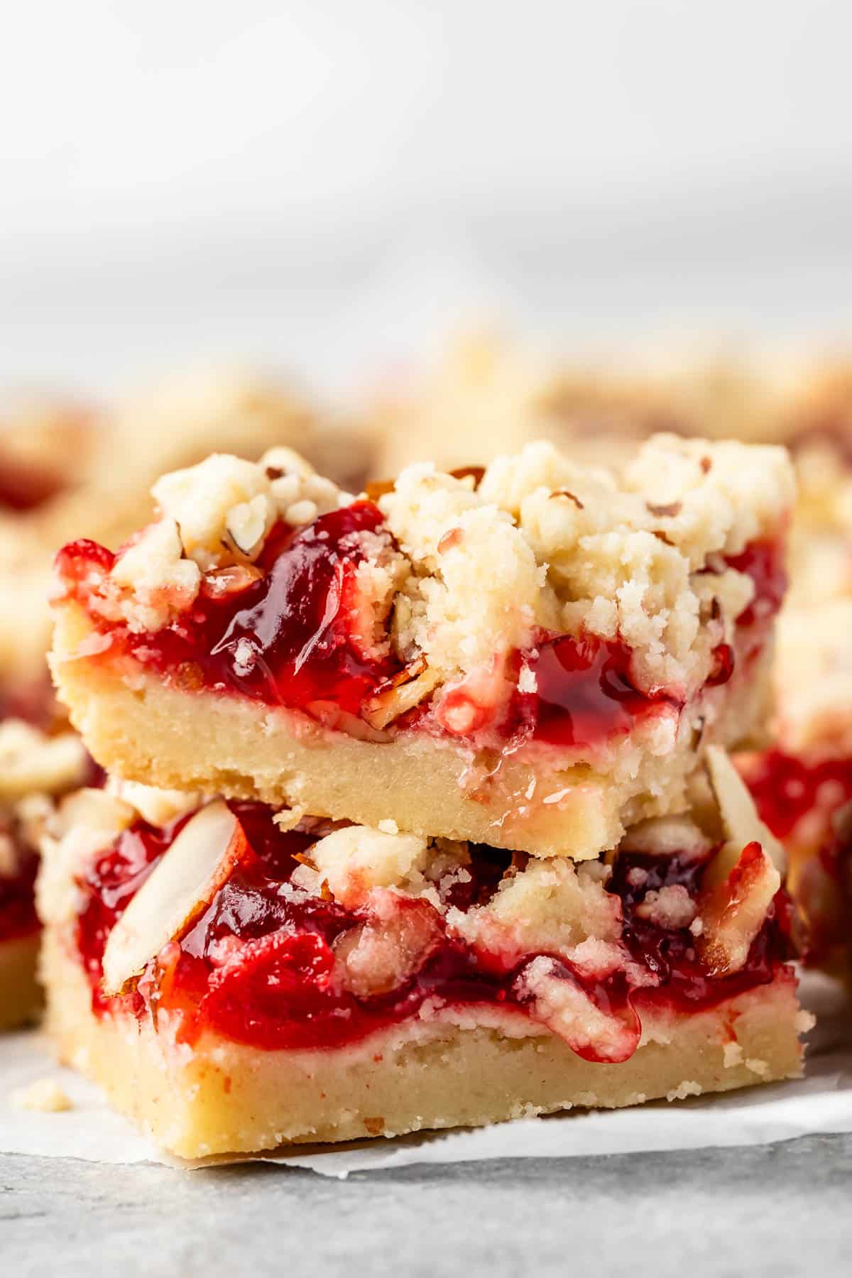 pie crust bars with red cherry pie filling and sliced almonds on top.