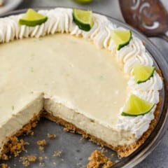 key lime pie with whipped cream and sliced limes on top.