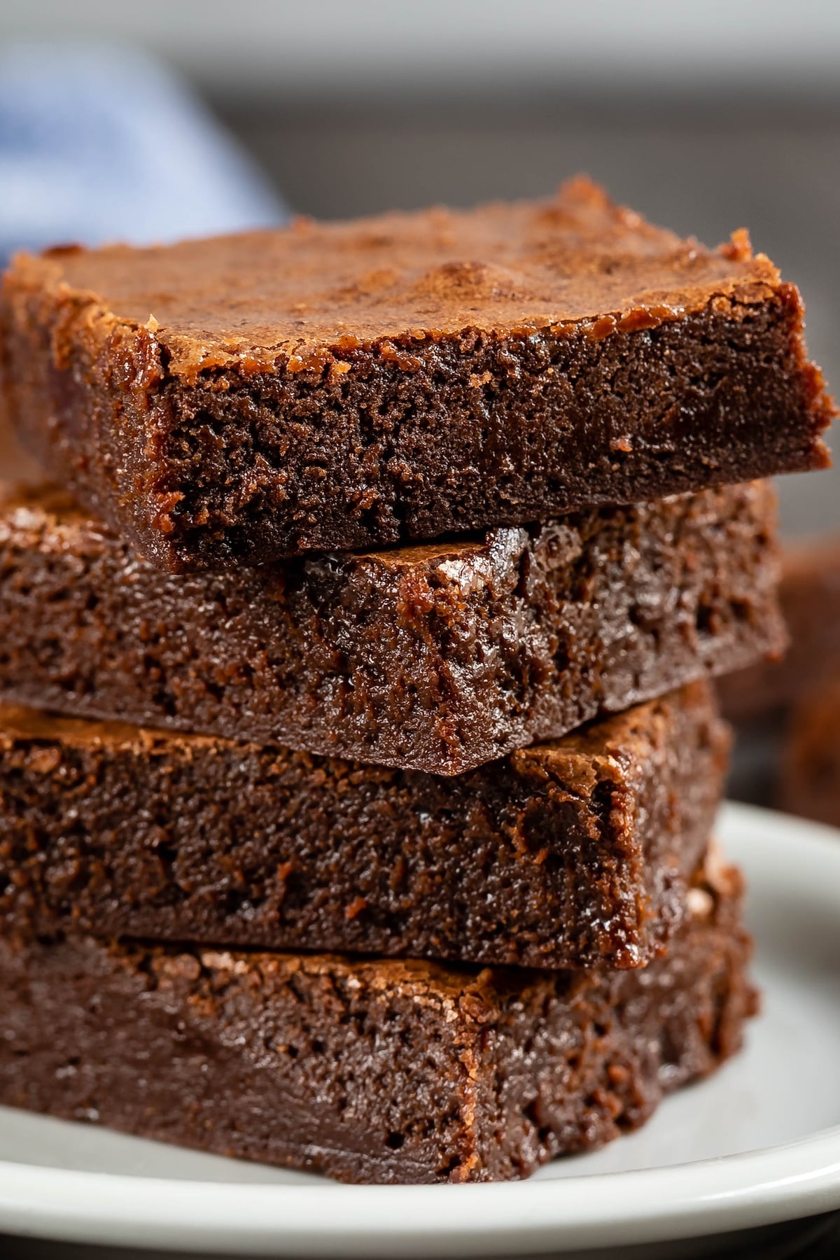 stacked brownies on a white plate.
