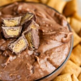 chocolate dip in a clear bowl surrounded by crackers.