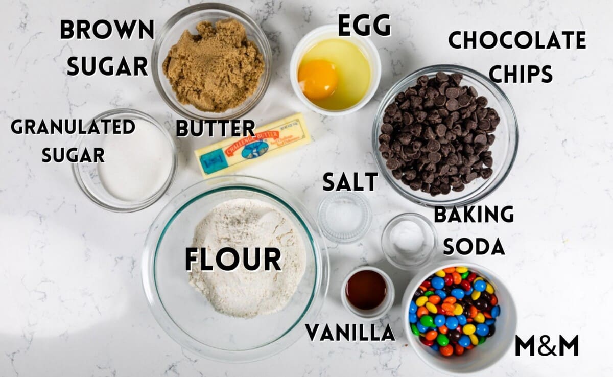 ingredients in M&M cookies laid out on a white countertop.