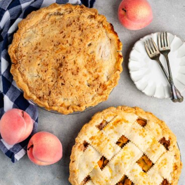 two peach pies with one being crumble topping and the other being lattice topped.