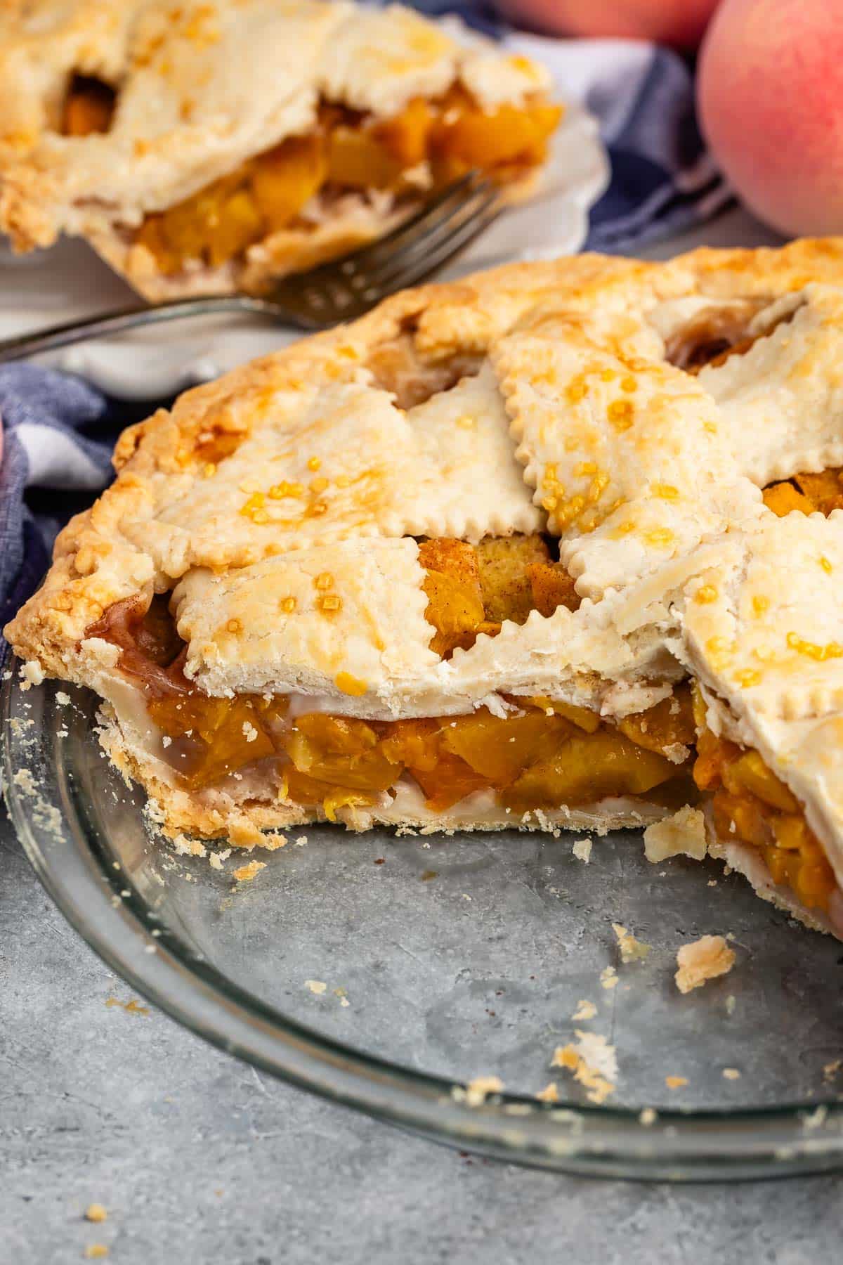 lattice topped pie with peached baked into the center in a clear pie.