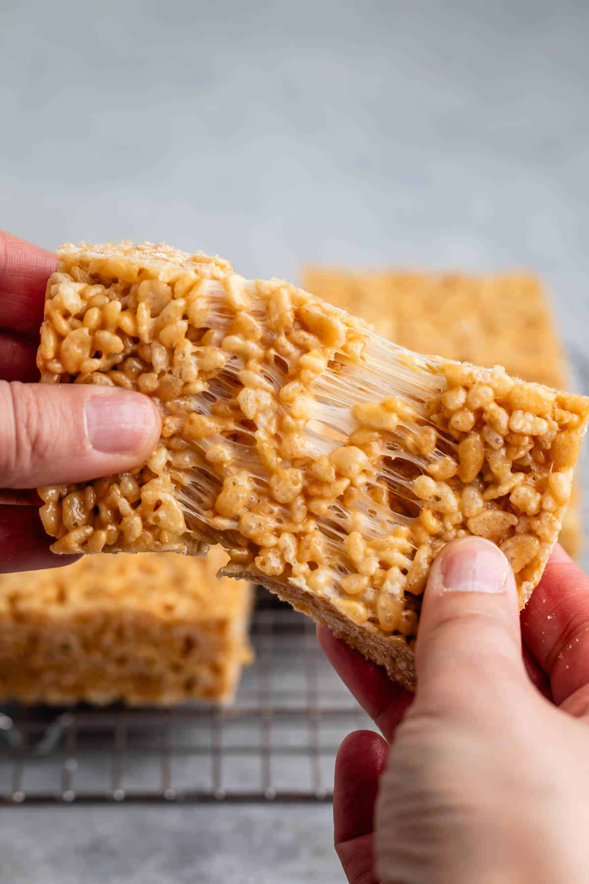 hand pulling Rice Krispie treats apart.