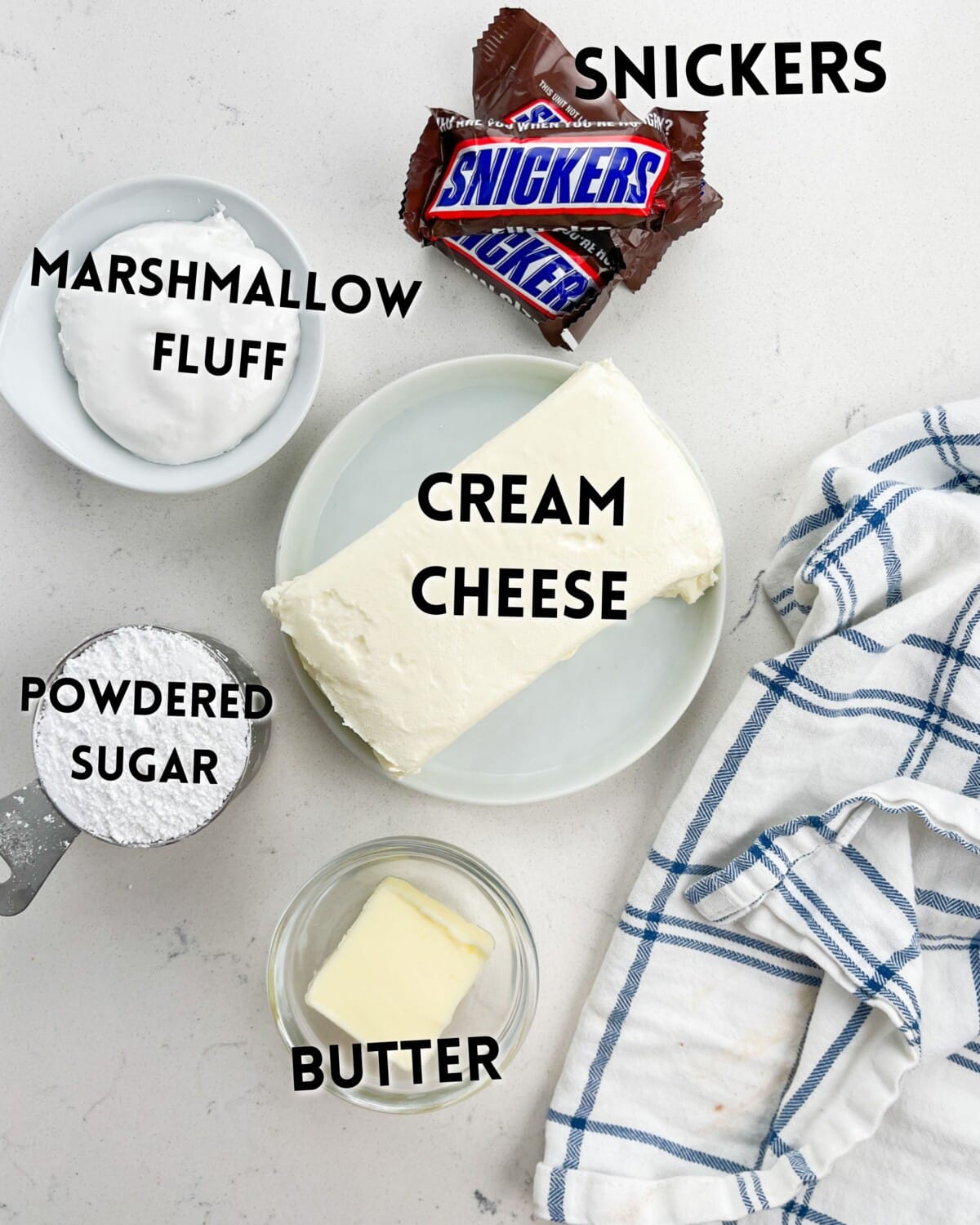 ingredients in snickers dip laid out on a marble counter.