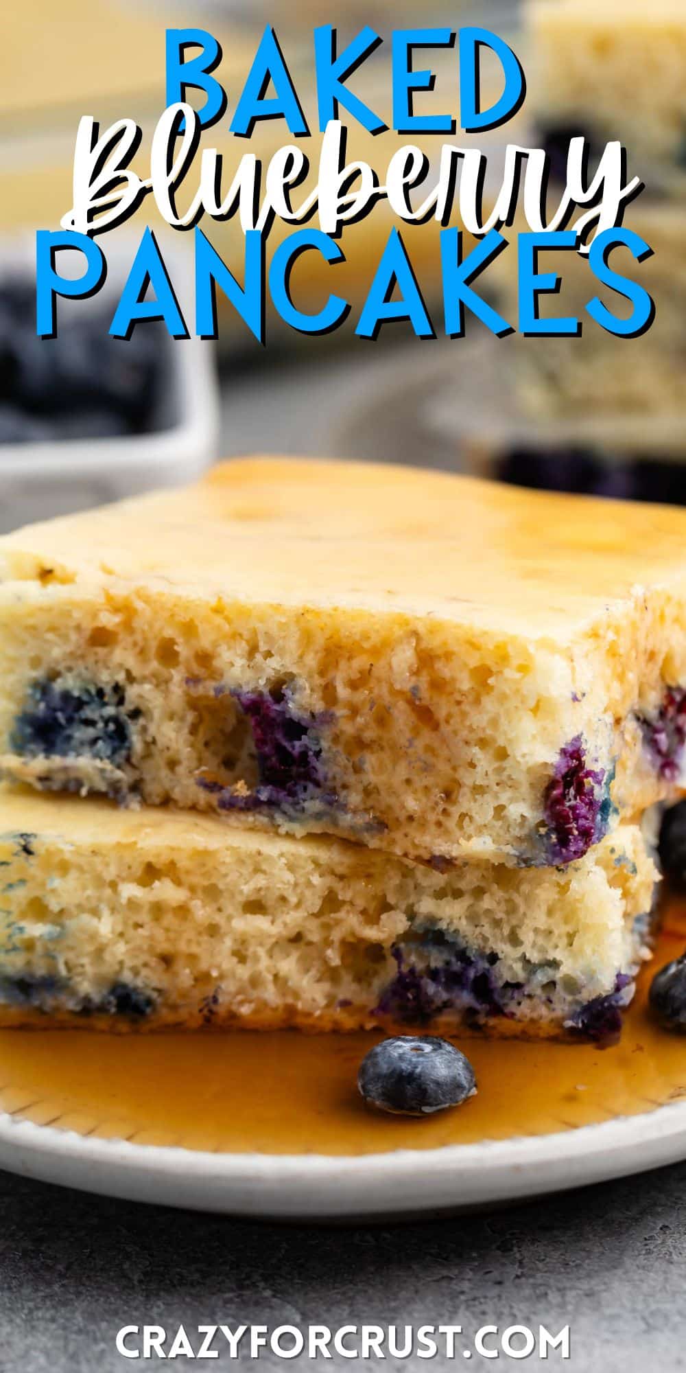 stacked square pancakes with blueberries baked in on a white plate with words on the image.