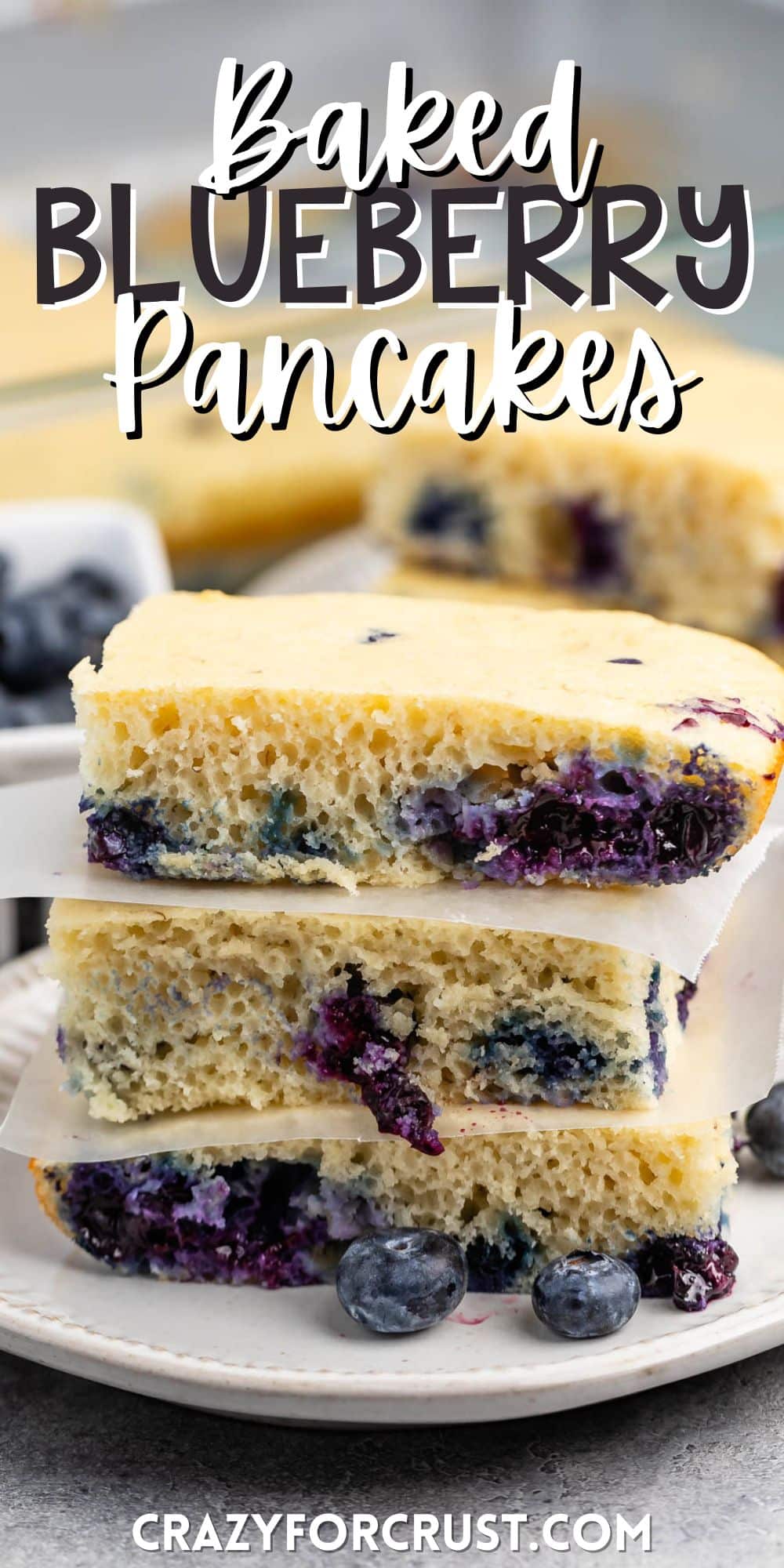 stacked square pancakes with blueberries baked in on a white plate with words on the image.