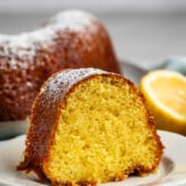 sliced bundt cake on a grey plate covered in powdered sugar.