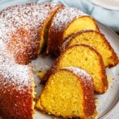 sliced bundt cake on a grey plate covered in powdered sugar.