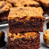 stacked brownies with peanut butter on top.